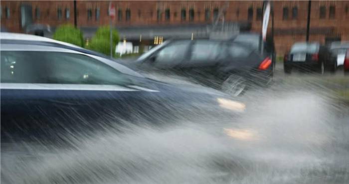 What should new energy vehicles do when they encounter heavy rain and water accu